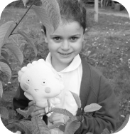 Image of a child at school holding a plush teddy of Betty. One of the many storybook characters from the myHappymind mental health and wellbeing program.